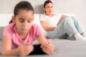 portrait-of-a-worried-mother-reading-while-daughte-2021-08-29-02-28-18-utc